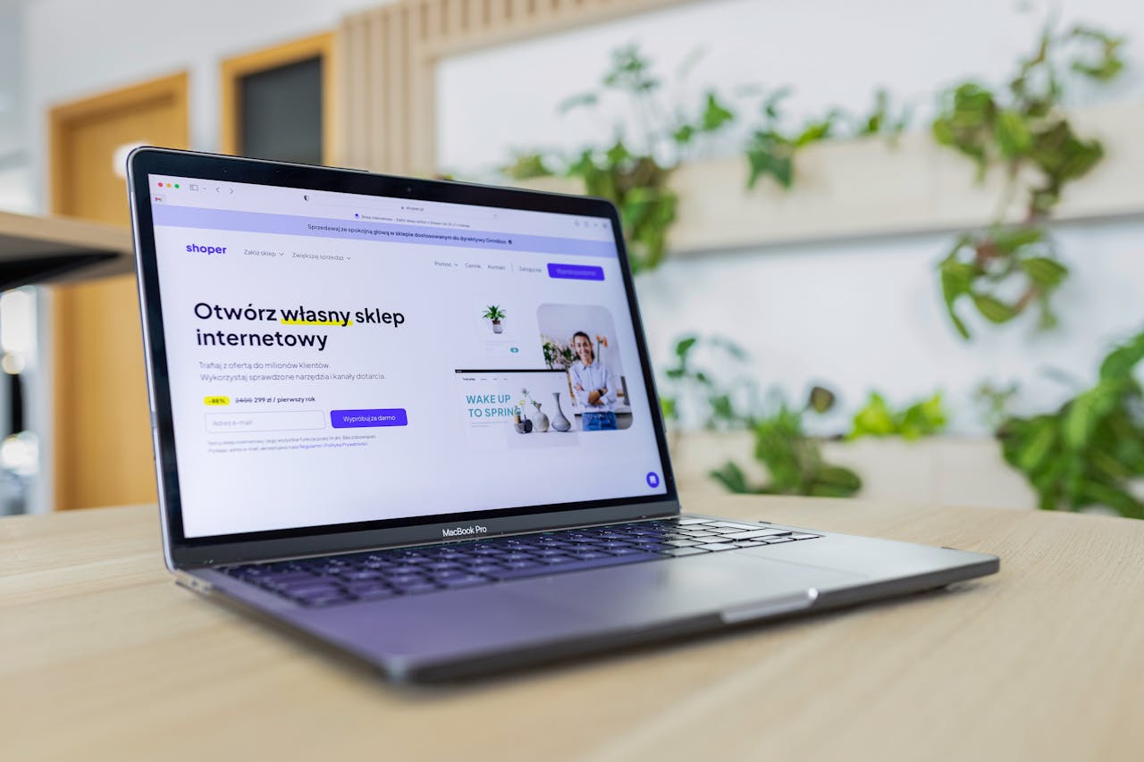 services-04 Close-up of a laptop with an open e-commerce website, surrounded by modern office decor.